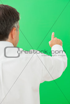 Businessman pointing to chroma key