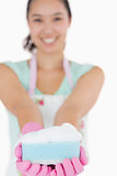 Smiling woman holding out a sponge