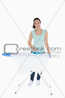 Happy woman doing the ironing