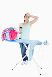 Woman drinking wine while ironing