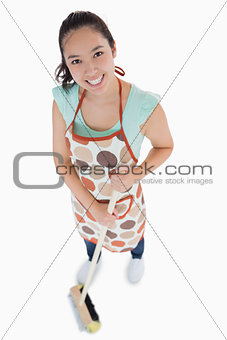 Smiling woman sweeping the floor