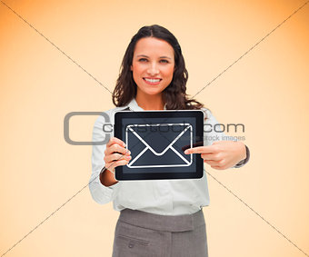 Businesswoman holding a tablet pc smiling and pointing at mail symbol