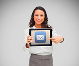 Businesswoman smiling while holding a tablet computer and pointing to mail symbol