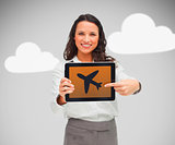 Businesswoman pointing at plane symbol on tablet pc
