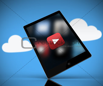 Tablet pc showing play button standing against background with clouds