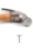 Hammer lying next to the nail