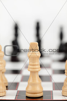 White queen standing at the chessboard