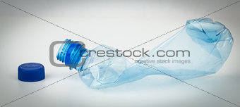 Empty plastic bottle crushed and blue cap