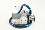Blue stethoscope wrapped around tiny house