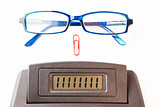 Sector of calculator display with glasses and paper clip