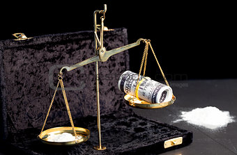 Weighing scales with dollars and drugs