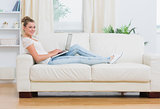 Blonde woman working on laptop on the couch