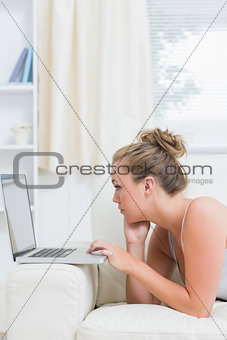 Blonde using laptop in living room