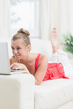 Smiling woman using laptop on the sofa
