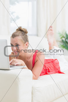 Smiling woman using laptop on the sofa