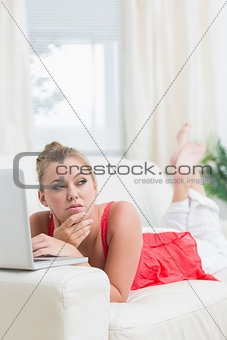Woman looking thoughtful while using notebook