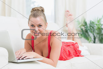 Blonde smiling while relaxing and using the notebook