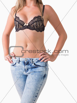 Woman in jeans and bra posing