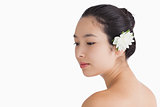Woman wearing a flower in hair and looking away