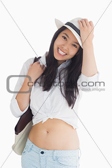 Woman with casual clothes holding her hat
