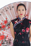 Woman wearing kimono standing with large fan