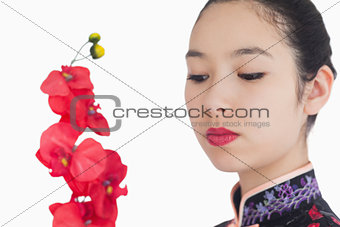 Woman in kimono looking at orchids