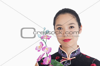 Woman holding an orchid while smiling