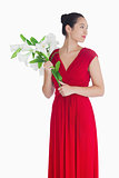 Woman in red dress holding lilies