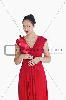 Woman in red evening gown holding orchids