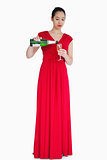 Woman in red dress pouring glass of champagne