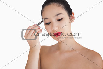 Woman holding a brush at her eyebrows
