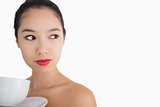 Woman holding a cup of coffee looking away