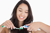 Woman putting toothpaste on toothbrush