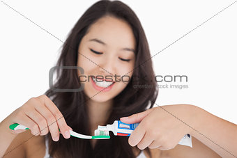 Woman putting toothpaste on toothbrush