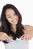 Woman smiling while holding a toothbrush and toothpaste