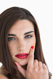 Woman touching her face with red lips