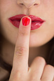 Woman touching her red lips with red nail