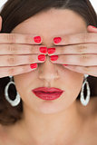 Woman hiding her eyes while wearing red