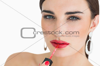 Woman applying red lip gloss