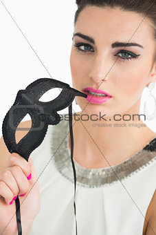 Woman dressed in sixties style holding a mask