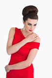 Woman in red dress holding her shoulder
