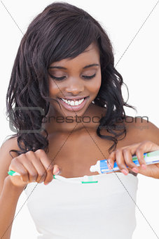 Woman putting toothpaste on brush