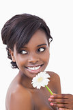 Woman looking away while smiling and holding a flower