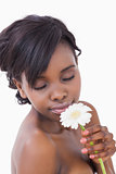 Woman smelling at a flower with eyes closed