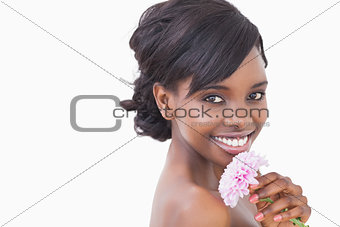 Pretty woman smiling while holding a pink coloured flower