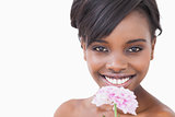 Woman smiling while holding a pink coloured flower