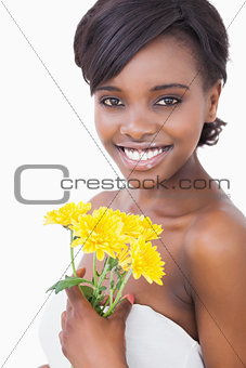 Woman smiling holding yellow flowers