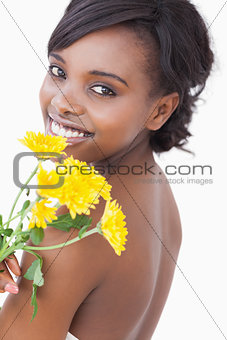 Woman looking over her shoulder holding flowers