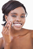 Smiling woman putting on cream