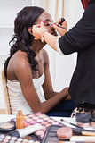 Woman sitting while getting makeup done